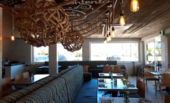 a restaurant with wooden walls and tables , a couch , and hanging decorations on the ceiling at Marinaterra Hotel & Spa