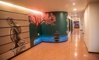 a long hallway with a mural of a tree and buddha on the wall , creating a serene and peaceful atmosphere at Aroma