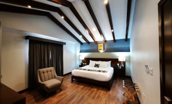a large bed with a white comforter is in the middle of a room with wooden floors and a chair at Casa San Miguel Hotel Boutique y Spa