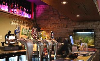 a bar with multiple beer taps and bottles of various sizes , suggesting a variety of types of drinks at Hampton Halfway Hotel Motel