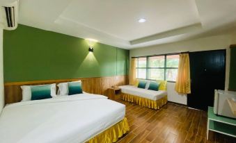 a hotel room with two beds , one on the left side and the other on the right side of the room at Suanpa Resort