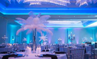 a beautifully decorated banquet hall with a white table covered in a blue tablecloth , surrounded by chairs and lit by candles at Homewood Suites by Hilton Allentown Bethlehem Center Valley