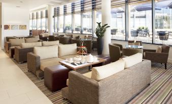 a large , open living room with multiple couches and chairs arranged around a coffee table at Crowne Plaza Reading East