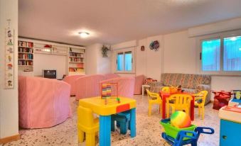 a brightly lit playroom filled with toys , including a variety of chairs and tables at Hotel Hamilton