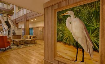 a hallway with a large painting of a white bird on the wall and a couch in the background at Disney's Vero Beach Resort