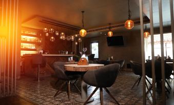 a dimly lit room with a dining table and chairs , as well as a bar area at The Opal