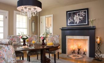 a dining room with a table , chairs , and a chandelier hanging above a fireplace at Gothic Eves Inn and Spa Bed and Breakfast
