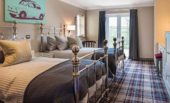 a bedroom with two beds , one on the left side and another on the right side of the room at The Sawley Arms