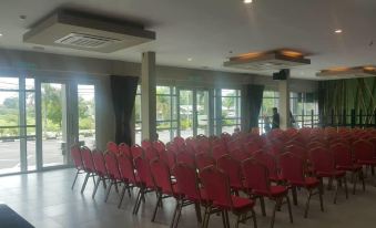 a large room with rows of red chairs arranged in a symmetrical pattern , ready for an event or meeting at Ants Hotel