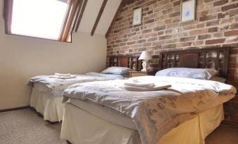 a room with two beds , one on top of the other , and a brick wall at Bluebell Farm
