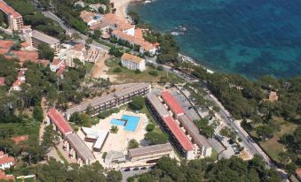 an aerial view of a resort near the ocean , featuring multiple buildings with a pool and a swimming pool at Aparthotel Comtat Sant Jordi