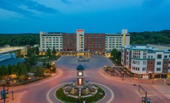 a large hotel with a clock in the center and other buildings surrounding it at night at Hyatt Regency Coralville Hotel & Conference Center