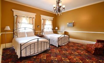 a room with two beds , one on the left and one on the right side of the room at Avon Inn