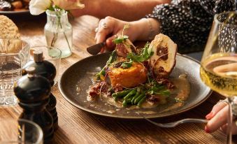 a person is sitting at a wooden table with a plate of food in front of them at The Globe