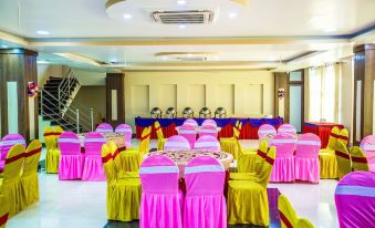 a large banquet hall with multiple tables covered in pink tablecloths and chairs arranged for a formal event at Hotel Avenue