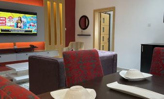 A two-bedroom apartment with a living room furnished with two tables and chairs at Millennium Apartments