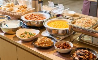 a buffet table filled with various dishes , including soups , meats , and other food items , as well as utensils such as spoons and forks at Meitetsu Inn Kariya