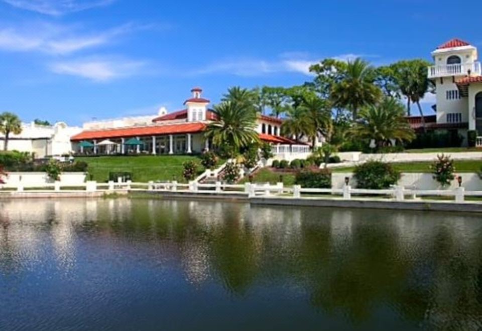 a large red building with a pool in front of it , surrounded by trees and grass at Mission Inn Resort & Club
