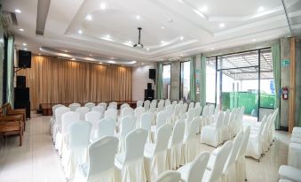 a large conference room with rows of white chairs arranged in a semicircle , ready for an event at Palmsuay Resort