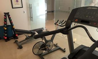 a room with various exercise equipment , including a treadmill , an elliptical machine , and a stationary bike at Casa Torres
