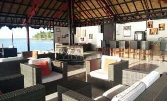 a spacious outdoor terrace with multiple dining tables , lounge chairs , and umbrellas , providing an elegant and inviting atmosphere at Tasik Ria Resort