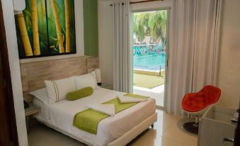 a well - appointed bedroom with a king - sized bed , a couch , and a door leading to a pool area at Riviera Del Sol Hotel Spa