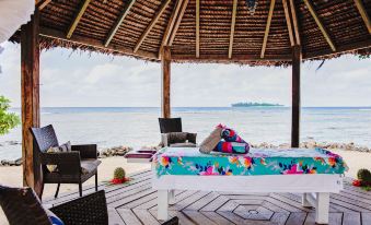 a wooden deck overlooking the ocean , with a massage table set up for a massage at Turtle Bay Lodge