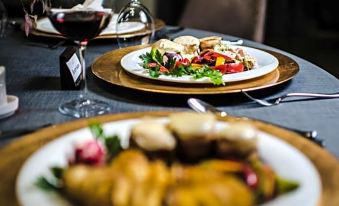 a dining table with two plates of food and a glass of wine , ready for a meal at Hotel River