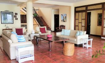 a spacious living room with white couches , a coffee table , and a staircase leading to the second floor at Sierra Resort