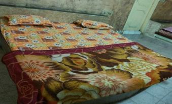 a bed with a floral comforter and matching pillows , placed in a room with a wooden floor at Paramount Hotel