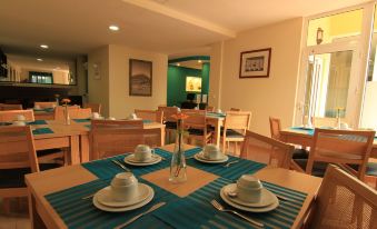 a dining room with a table set for a meal , featuring white plates , cups , and utensils at Hotel Santa Maria