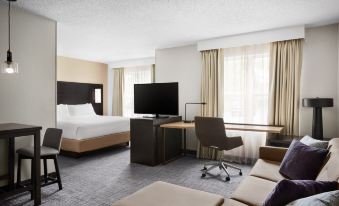 a hotel room with a large bed , a couch , a television , and a dining table at Residence Inn Harrisburg Carlisle