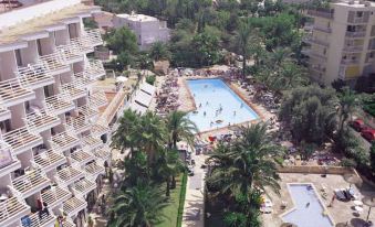 aerial view of a resort with a large pool surrounded by multiple buildings , including a hotel and a resort at Globales Palmanova