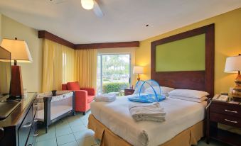 a well - decorated hotel room with a large bed , nightstands , and a window , as well as a desk and a couch at Fiesta Resort All Inclusive Central Pacific - Costa Rica