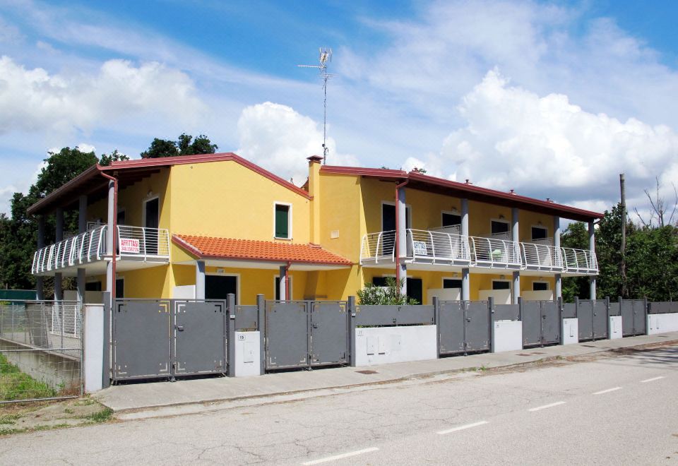 a row of yellow and gray houses with gray fences on the side of a road at Dora