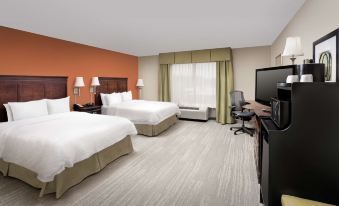 a hotel room with two beds , a tv , and a desk , all neatly arranged in a well - lit area at Hampton Inn Lenoir City