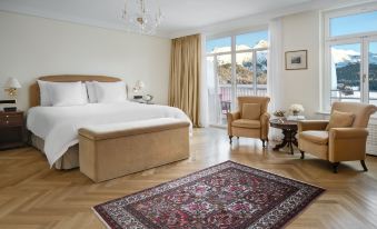 a spacious bedroom with a large bed , two chairs , and a rug on the floor at Badrutt's Palace Hotel St Moritz