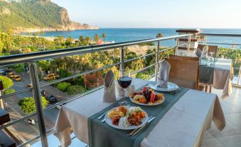 a dining table set with a variety of food and drinks , including a plate of food , a bowl of soup , and a cup of coffee at Gardenia Hotel