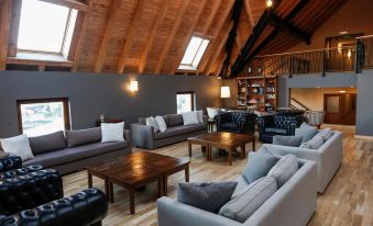 a large living room with multiple couches and chairs arranged around a coffee table , creating a cozy atmosphere at Los Cerros del Chalten Boutique Hotel