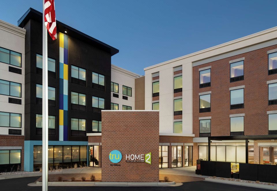 "a modern hotel building with the word "" home "" displayed on its facade , and a flag in front of it" at Home2 Suites by Hilton Ogden