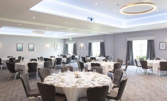 a large , empty conference room with round tables and chairs set up for a formal event at Eastwood Hall