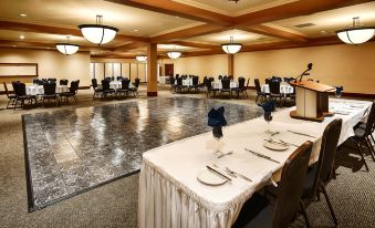a large banquet hall with tables covered in white tablecloths and chairs arranged around them at Best Western Plus Barclay Hotel