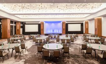 a large , well - lit conference room with multiple tables and chairs arranged for a meeting or event at Hilton Dallas Lincoln Centre