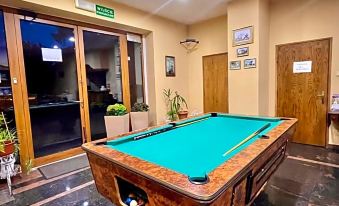 a billiards table in a room with two doors , one on the left and one on the right at Titanic