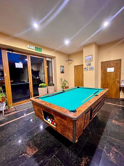 a billiards table in a room with two doors , one on the left and one on the right at Titanic