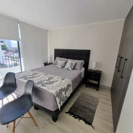 In front of Hospital U. de Chile with parking lot.