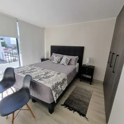 In front of Hospital U. de Chile with parking lot.