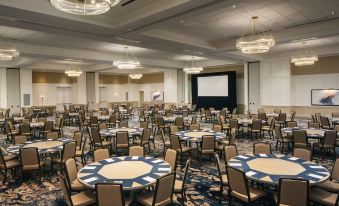 a large conference room with multiple round tables and chairs , all set up for an event at Wild Dunes Resort