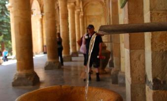 a group of people , including a man and a woman , are standing in an old building , surrounded by columns and water at Hotel Central