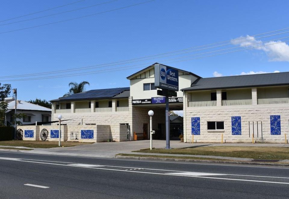 "a building with a blue sign that says "" sun and sand "" is located on the side of a road" at Best Western Caboolture Gateway Motel
